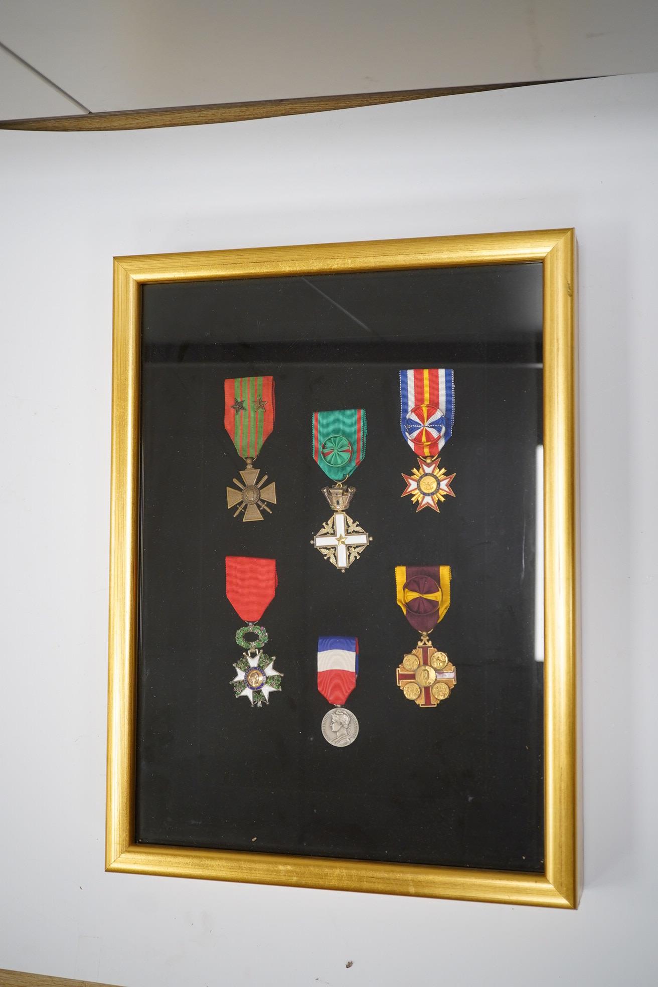 A framed medal group; Legion D'Honneur France, a British Cross, Italian order of Merit and Croix De Guerre with related book; La Legion d’Honneur by Jean Daniel, plus some related paperwork, three related medal miniature